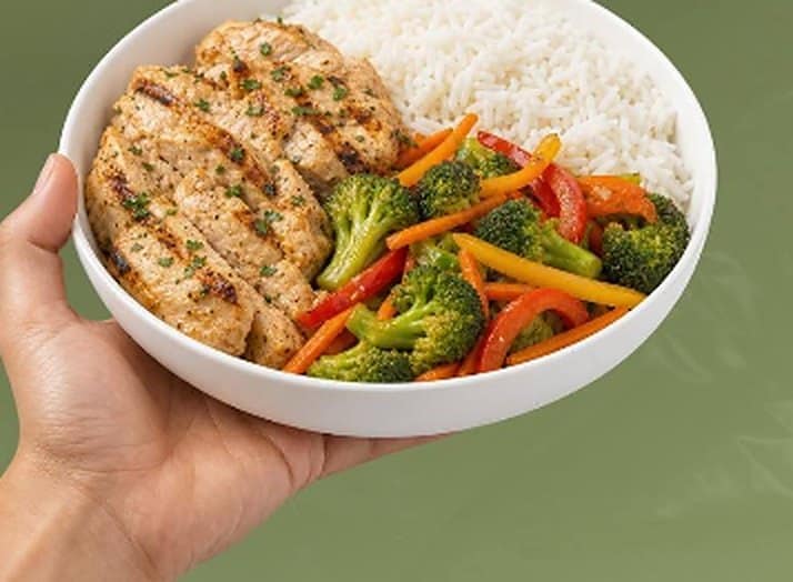 Prato com filé de frango grelhado, arroz e legumes coloridos